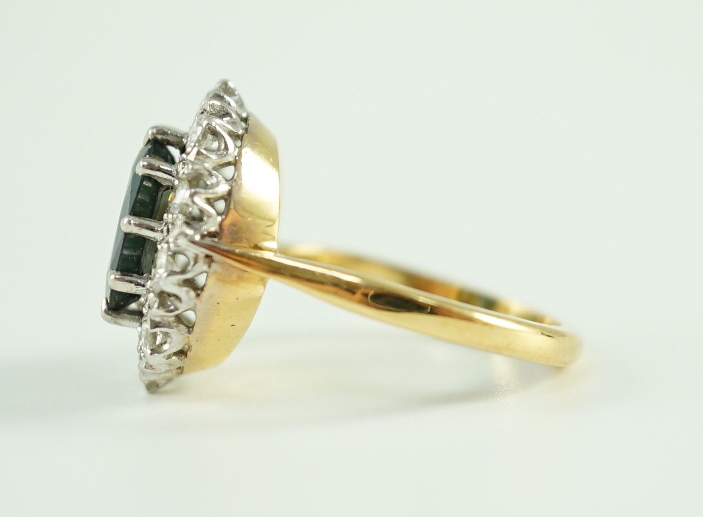 An 18ct gold, sapphire and diamond set oval cluster dress ring